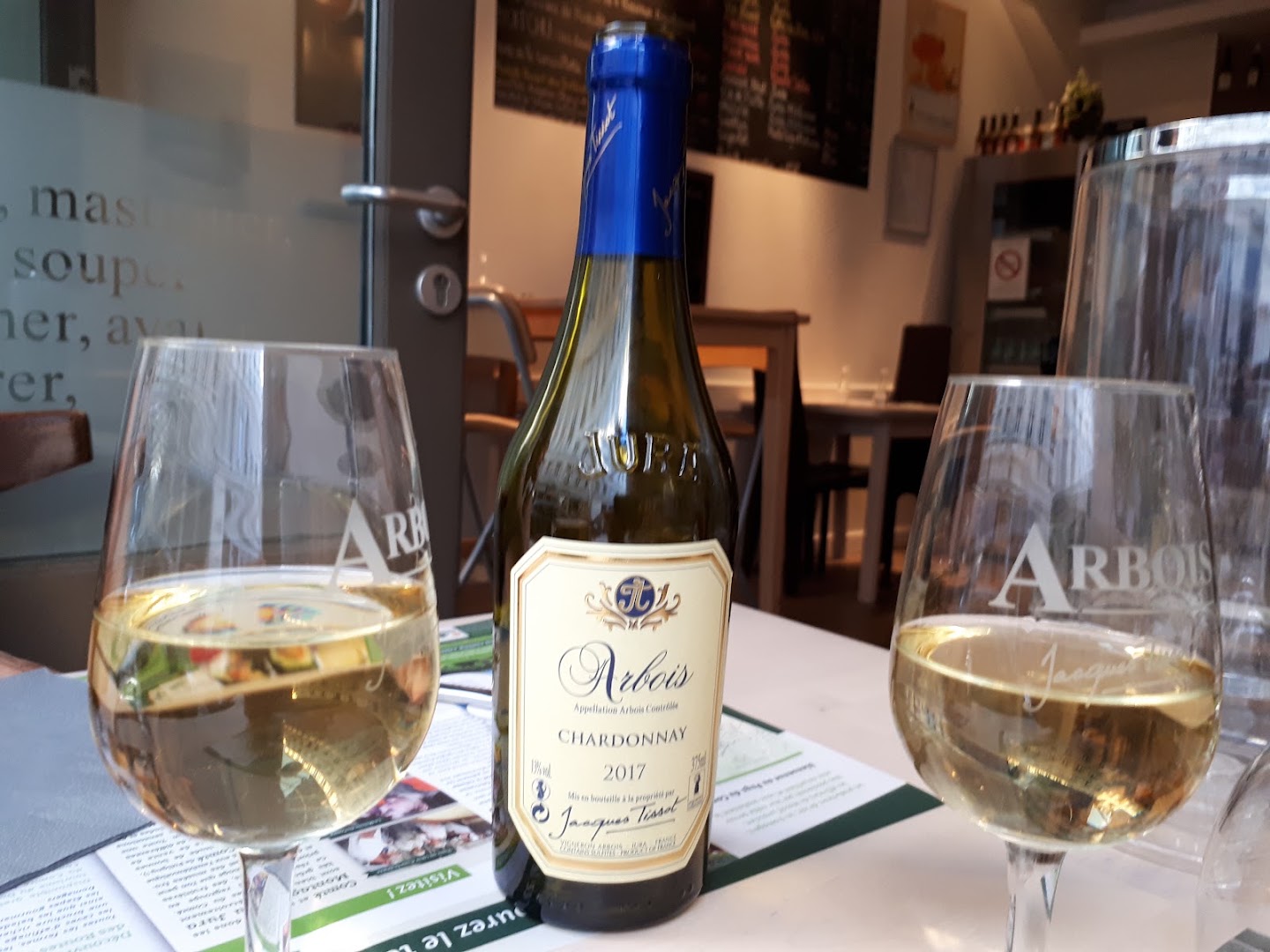 Une bouteille de vin du Jura accompagnée d’un verre